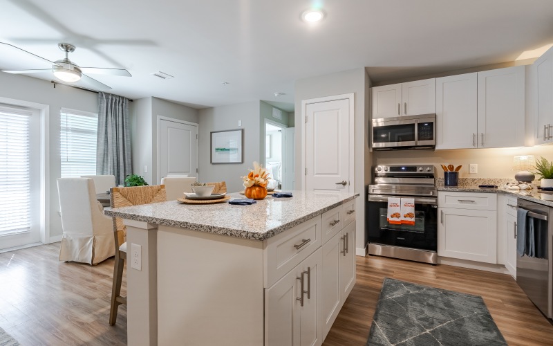 kitchen with white cabinets, stainless steel appliances and island with granite counters
