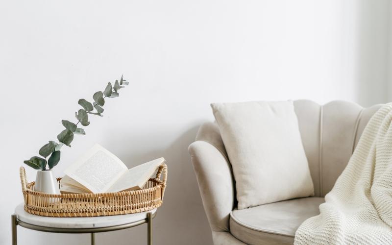 a white couch and a table with a basket and a plant on it